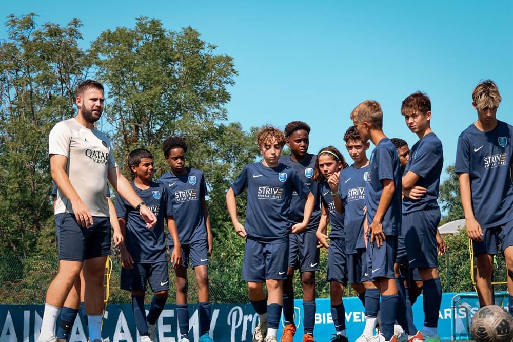 Grupo de jugadores con su entrenador en el PSG Academy Pro Évian